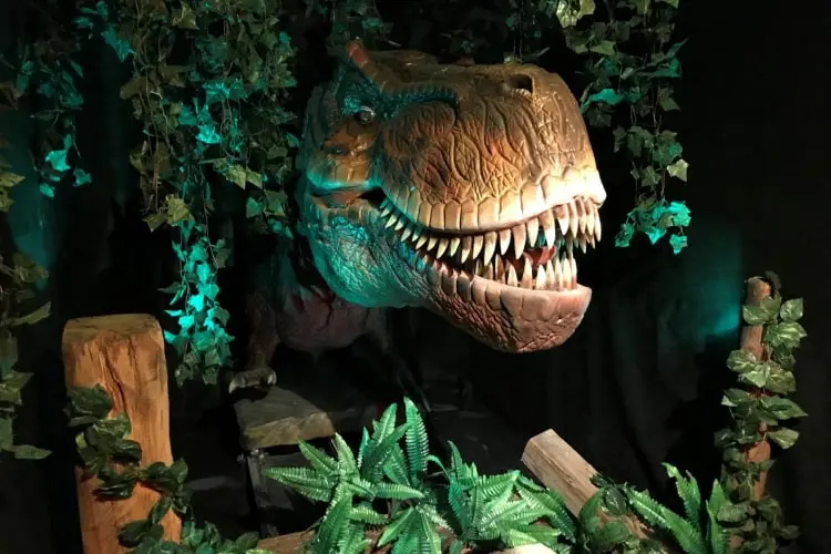 Ein imposanter T-Rex-Kopf ragt aus dem Dschungel – eine spektakuläre Attraktion im Tirolland, perfekt für einen spannenden Ausflug in Tirol.