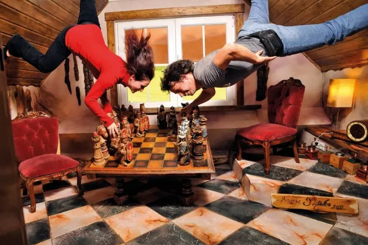 Ein Paar spielt Schach in einem Raum, der kopfüber steht – eine verblüffende optische Illusion beim Ausflug in Tirol im Tirolland.