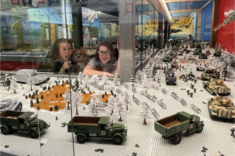 Zwei Frauen bestaunen eine beeindruckende LEGO-Kriegsszene mit Fahrzeugen und Soldaten – eine faszinierende Miniaturwelt beim Ausflug in Tirol im Tirolland.