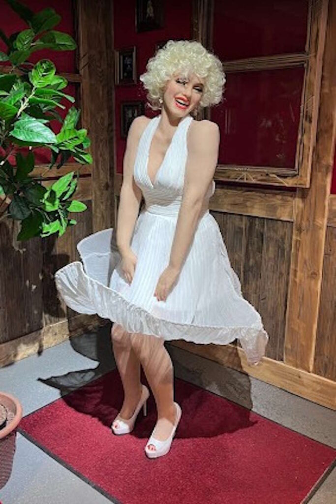 Eine täuschend echte Wachsfigur von Marilyn Monroe in ikonischer Pose im Tirolland – ein Highlight für Filmfans beim Ausflug in Tirol.